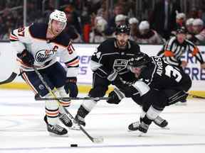 Connor McDavid # 97 des Oilers d'Edmonton patine avec la rondelle devant Viktor Arvidsson # 33 et Phillip Danault # 24 des Kings de Los Angeles lors d'une victoire 3-2 des Oilers au Crypto.com Arena le 07 avril 2022 à Los Angeles, Californie.