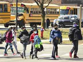 Des élèves traversent la rue à l'école intermédiaire Tomken Road à Mississauga, en Ontario.