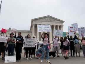 Des manifestants brandissent des pancartes lors d'une manifestation devant la Cour suprême des États-Unis après la fuite d'un projet d'avis majoritaire rédigé par le juge Samuel Alito se préparant à ce qu'une majorité du tribunal annule la décision historique Roe v. Wade sur les droits à l'avortement plus tard cette année, à Washington, en mai. 4, 2022.