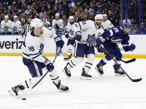 L'ailier droit des Maple Leafs de Toronto William Nylander, à gauche, tire contre le Lightning de Tampa Bay lors des prolongations du sixième match du premier tour des séries éliminatoires de la Coupe Stanley 2022 à l'Amalie Arena de Tampa, en Floride, le 12 mai 2022.