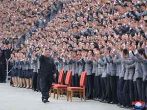 Kim Jong Un salue les étudiants et les jeunes travailleurs, qui sont tous démasqués, lors d'une séance photo à Pyongyang, en Corée du Nord, sur cette photo non datée publiée par l'Agence centrale de presse coréenne de Corée du Nord le 1er mai 2022.