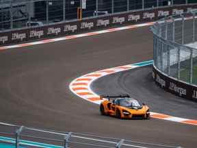 Des ingénieurs et des officiels conduisent une voiture de sport sur la piste de Formule 1 avant le Grand Prix de Miami à Miami Gardens, en Floride, le 4 mai 2022.