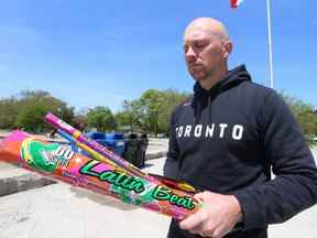 Le conseiller municipal de Toronto, Brad Bradford, du quartier 19, Beaches-East York, tient certains des feux d'artifice usés et jetés qu'il a ramassés lors d'une courte promenade près de Woodbine Beach, le mardi 24 mai 2022.