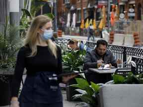 Des gens s'assoient sur une terrasse extérieure à Toronto.