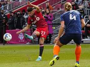 Le milieu de terrain du Toronto FC Jonathan Osorio (21) lance le ballon alors que le défenseur du FC Cincinnati Nick Hagglund (4) défend pendant la première moitié au BMO Field.