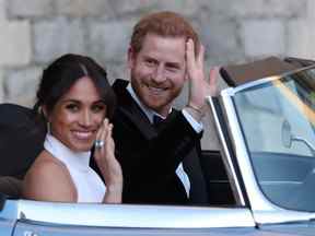 Meghan, la duchesse de Sussex et le prince Harry saluent alors qu'ils quittent le château de Windsor après leur mariage pour assister à une réception en soirée à Frogmore House, organisée par le prince de Galles le 19 mai 2018 à Windsor, en Angleterre.  (Photo de Steve Parsons - Piscine WPA/Getty Images)