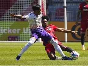 14 mai 2022 ;  Toronto, Ontario, CAN ;  Le milieu de terrain du Toronto FC Ralph Priso-Mbongue frappe le ballon loin du milieu de terrain du Orlando City SC Facundo Torres au BMO Field.