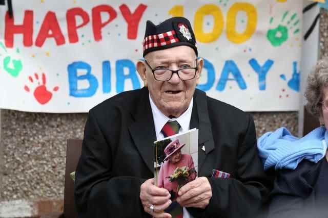 L'ancien Royal Scots George Simpson devant sa maison à Danderhall, Midlothian, avec sa carte de la reine, pour marquer son 100e anniversaire David Cheskin/PA)