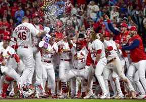 Le joueur de premier but des Cardinals de St. Louis, Paul Goldschmidt, est félicité par ses coéquipiers au marbre après avoir frappé un grand chelem contre les Blue Jays de Toronto lors de la dixième manche au Busch Stadium de St. Louis, Miss., le 23 mai 2022.