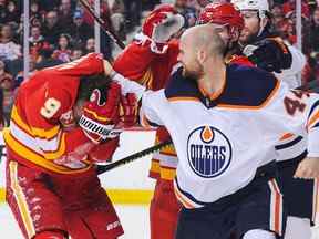 Zack Kassian (44 ans) des Oilers d'Edmonton frappe Matthew Tkachuk (19 ans) des Flames de Calgary lors d'un match de la LNH au Scotiabank Saddledome le 11 janvier 2020 à Calgary.