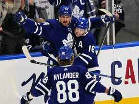 Mitchell Marner et William Nylander des Maple Leafs félicitent Auston Matthews pour son but contre le Lightning de Tampa Bay lors de la deuxième période du premier match de leur série éliminatoire de première ronde de la Coupe Stanley au Scotiabank Arena le lundi 2 mai 2022.