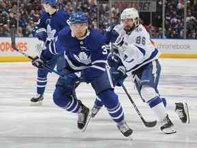 Nikita Kucherov du Lightning de Tampa Bay patine contre Justin Holl des Maple Leafs de Toronto lors du cinquième match du premier tour des séries éliminatoires de la Coupe Stanley 2022 à la Scotiabank Arena le 10 mai 2022 à Toronto, Ontario, Canada.