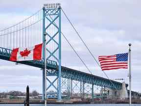 Des drapeaux canadiens et américains flottent près du pont Ambassador au passage frontalier canado-américain à Windsor, en Ontario.