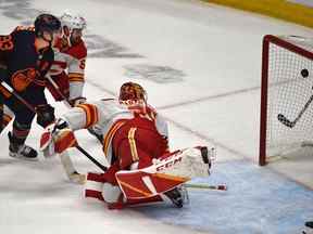 L'attaquant des Oilers d'Edmonton Ryan Nugent-Hopkins marque l'éventuel vainqueur du match contre le gardien des Flames de Calgary Jacob Markstrom alors qu'il affrontait le défenseur Oliver Kylington lors du quatrième match de leur série éliminatoire de deuxième tour à Rogers Place à Edmonton le 24 mai 2022.