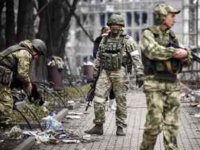 Des soldats russes se promènent dans une rue de Marioupol.