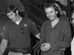 Dans cette photo d'archive de 1977, le tueur en série Ted Bundy, au centre, est escorté hors du tribunal au palais de justice du comté de Pitkin, Aspen, Colorado (Ross Dolan/Glenwood Springs Post Independent via AP)