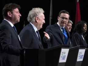 Le candidat à la direction du parti conservateur Pierre Poilievre fait un geste vers Jean Charest alors que Roman Baber, à gauche, Scott Aitchison et Leslyn Lewis, à droite, débattent à la conférence du Réseau Canada Strong and Free à Ottawa le 5 mai 2022.