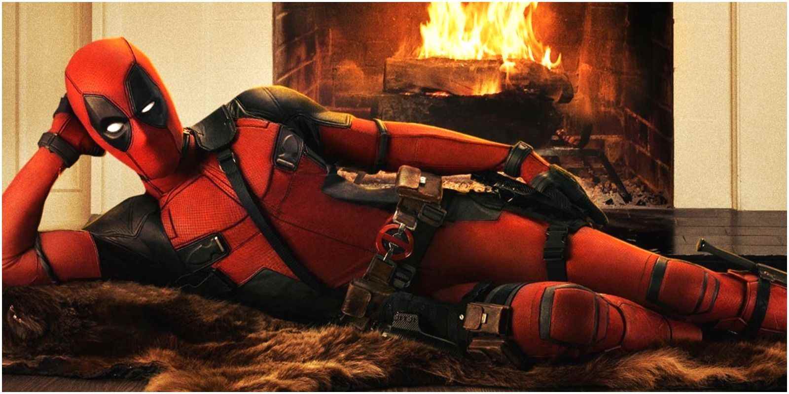 Deadpool (Ryan Reynolds) lies seductively on a bearskin rug in front of a fire