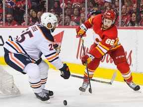 Andrew Mangiapane des Flames de Calgary se bat pour la rondelle contre Darnell Nurse des Oilers d'Edmonton lors de la troisième période du premier match de la deuxième ronde des séries éliminatoires de la Coupe Stanley 2022 au Scotiabank Saddledome le 18 mai 2022 à Calgary, Alberta, Canada.