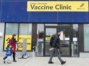 Des gens passent devant une clinique de vaccination pendant la pandémie de COVID-19 à Mississauga, en Ontario.