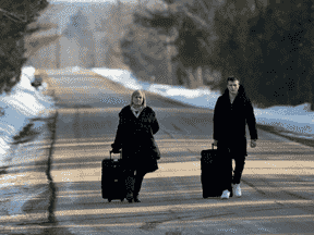 Des demandeurs d'asile entrent au Canada depuis la frontière américaine près d'un point de contrôle sur le chemin Roxham près de Hemmingford, Québec, Canada, le 24 avril 2022.