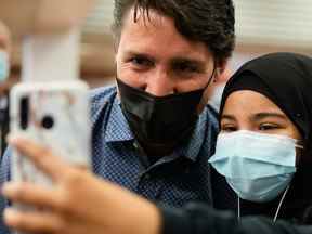 Le premier ministre Justin Trudeau prend un selfie avec un partisan, après que les libéraux ont remporté un gouvernement minoritaire, à la station de métro Jarry à Montréal, le 21 septembre 2021.