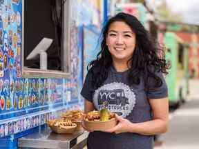 La copropriétaire du camion de restauration Dumpling Hero, Tracy Cheng, pose pour une photo tenant un sandwich au porc lors de l'événement de lancement de nourriture à mi-chemin du Stampede de Calgary le mardi 17 mai 2022.