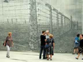 Des gens au Monument national de l'Holocauste à Ottawa.