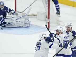 Le défenseur du Lightning de Tampa Bay, Victor Hedman, célèbre son but avec ses coéquipiers Alex Killorn et Steven Stamkos après avoir marqué devant le gardien des Maple Leafs Jack Campbell lors de la première période du deuxième match, le mercredi 4 mai 2022.