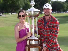 Sam Burns, des États-Unis, pose avec le trophée Leonard et portant la veste à carreaux du Colonial Country Club avec sa femme Caroline après avoir gagné sur le 18e green lors du premier trou des séries éliminatoires lors de la dernière ronde du Charles Schwab Challenge au Colonial Country Club le 29 mai 2022 à Fort Worth, Texas.  (Photo de Tom Pennington/Getty Images)