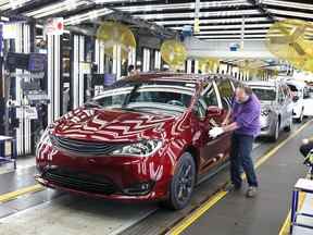 L'inspecteur Frank Calzavara est représenté avec une Chrysler Pacifica hybride en rouge velours dans la zone « dernière voiture » de l'usine d'assemblage de FCA Canada à Windsor.