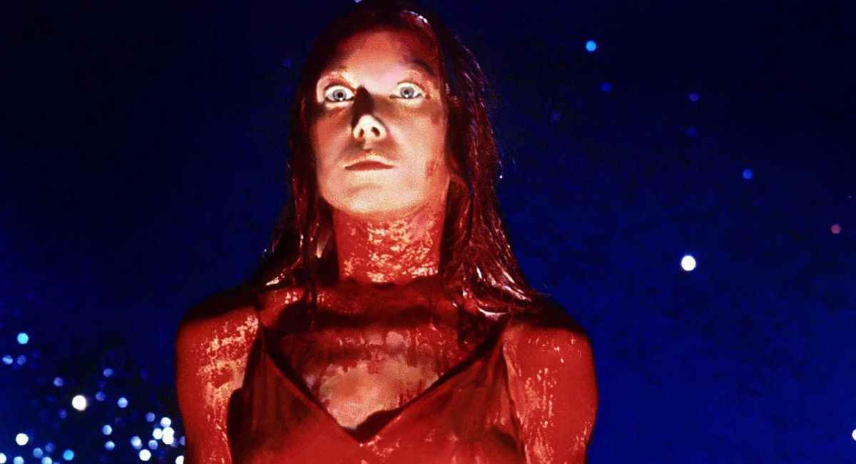 Sissy Spacek dans le rôle de Carrie regardant dans une robe de bal recouverte de sang de porc à Carrie.