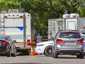 Des enquêteurs de la police travaillent sur les lieux d'un homicide après une invasion de domicile sur la place du Comoran à Laval, au nord de Montréal, le mardi 24 mai 2022.