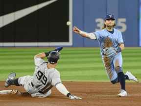 L'arrêt-court des Blue Jays Bo Bichette lance au premier but après qu'Aaron Judge des Yankees de New York ait été expulsé au deuxième but lors de la quatrième manche à Toronto le mercredi 4 mai 2022.