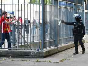 La police pulvérise des gaz lacrymogènes sur les supporters de Liverpool à l'extérieur du stade alors qu'ils font la queue avant le match final de l'UEFA Champions League entre le Liverpool FC et le Real Madrid au Stade de France le 28 mai 2022 à Paris, France.  (Photo de Matthias Hangst/Getty Images)