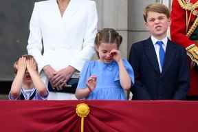 Le prince Louis (à gauche), la princesse Charlotte et le prince George réagissent en regardant un défilé aérien spécial depuis le balcon du palais de Buckingham à Londres le 2 juin 2022. (Photo de DANIEL LEAL/AFP via Getty Images)