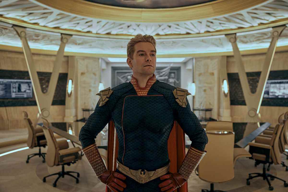 Homelander se tient dans la salle de réunion des Seven dans une pose de héros dans la saison 3 de The Boys.