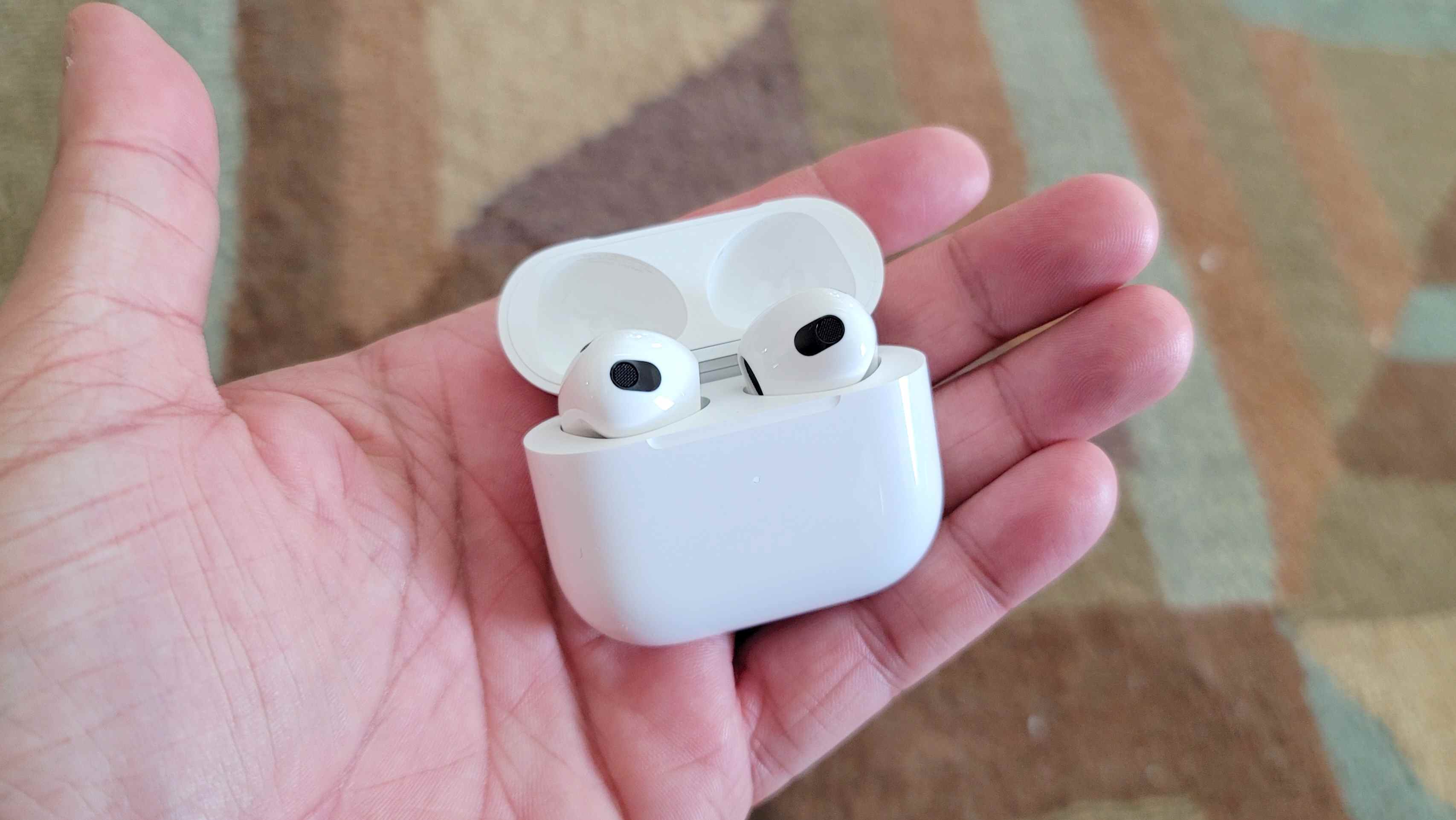 Le boîtier de charge de l'Apple AirPods 3 tenu en main