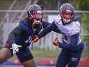 Le secondeur Reshard Cliett porte une visière kaléidoscopique alors qu'il couvre le receveur Dante Absher lors de l'entraînement au camp d'entraînement des Alouettes de Montréal à Trois-Rivières le 26 mai 2022.