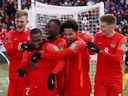 Le junior Hoilett du Canada célèbre le pointage avec ses coéquipiers lors d'une qualification pour la Coupe du monde au BMO Field à Toronto le 27 mars 2022.