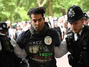 Un homme est détenu par la police alors que les gens se rassemblent sur le centre commercial, avant le concert de la BBC Platinum Party au palais, devant le palais de Buckingham lors des célébrations du jubilé de platine de la reine Elizabeth en Grande-Bretagne, à Londres, en Grande-Bretagne, le 4 juin 2022. REUTERS/Dylan Martinez