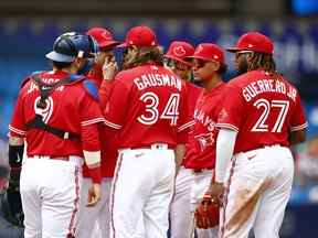 L'entraîneur des lanceurs des Blue Jays, Pete Walker, s'entretient avec Kevin Gausman et ses coéquipiers lors de la deuxième manche lors d'un match de la MLB contre les Twins du Minnesota au Rogers Center le 05 juin 2022 à Toronto.