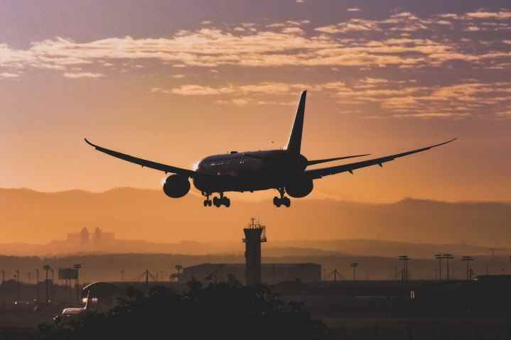 Un avion atterrissant dans un aéroport au crépuscule.