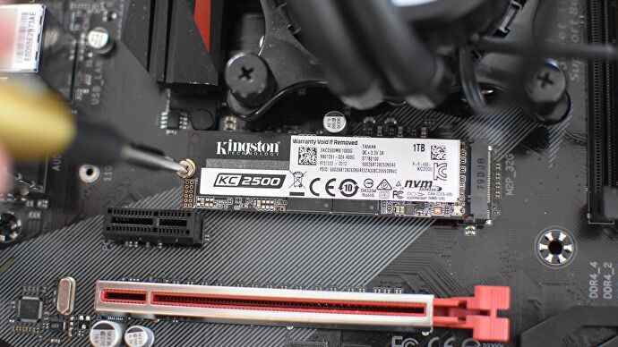 Un SSD NVMe étant fixé dans son emplacement M.2 par un petit tournevis.