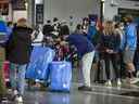 Les gens font la queue à l'aéroport international Pearson de Toronto le mardi 3 mai 2022.