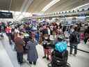 Les voyageurs attendent dans la file d'attente au terminal 1 de l'aéroport Pearson de Toronto, le jeudi 9 mai 2022. 