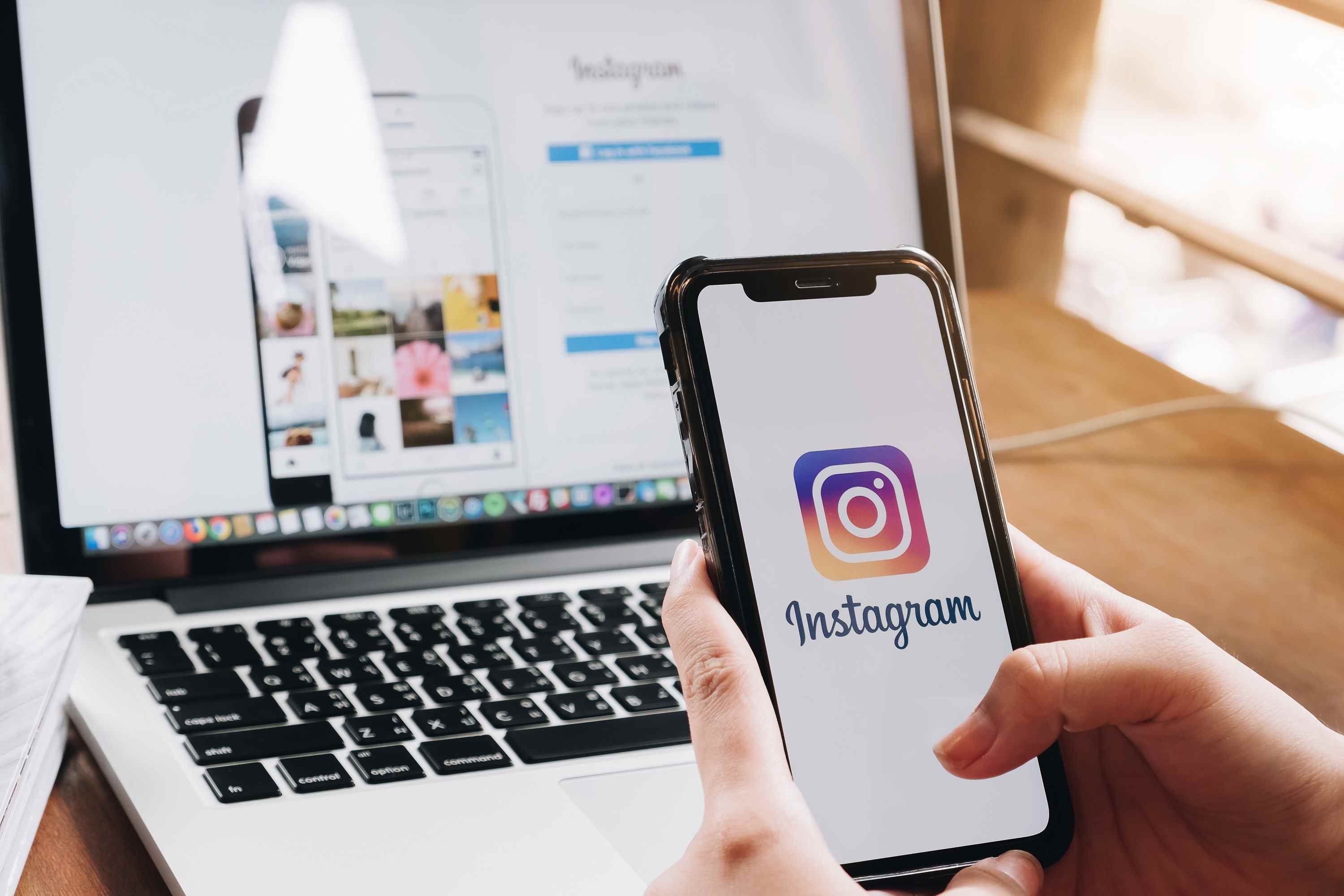 Logo Instagram sur iPhone avec site Web Instagram en arrière-plan.