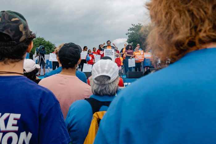 Des membres de la foule regardent un éducateur prononcer un discours lors de la deuxième Marche pour nos vies.