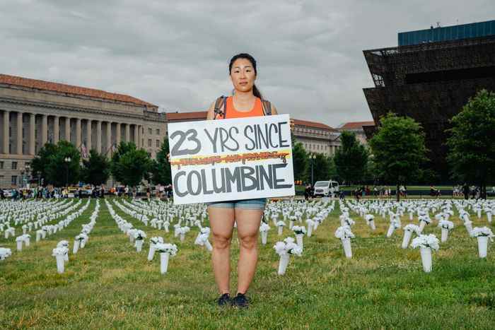 Une femme en short tient une pancarte indiquant 