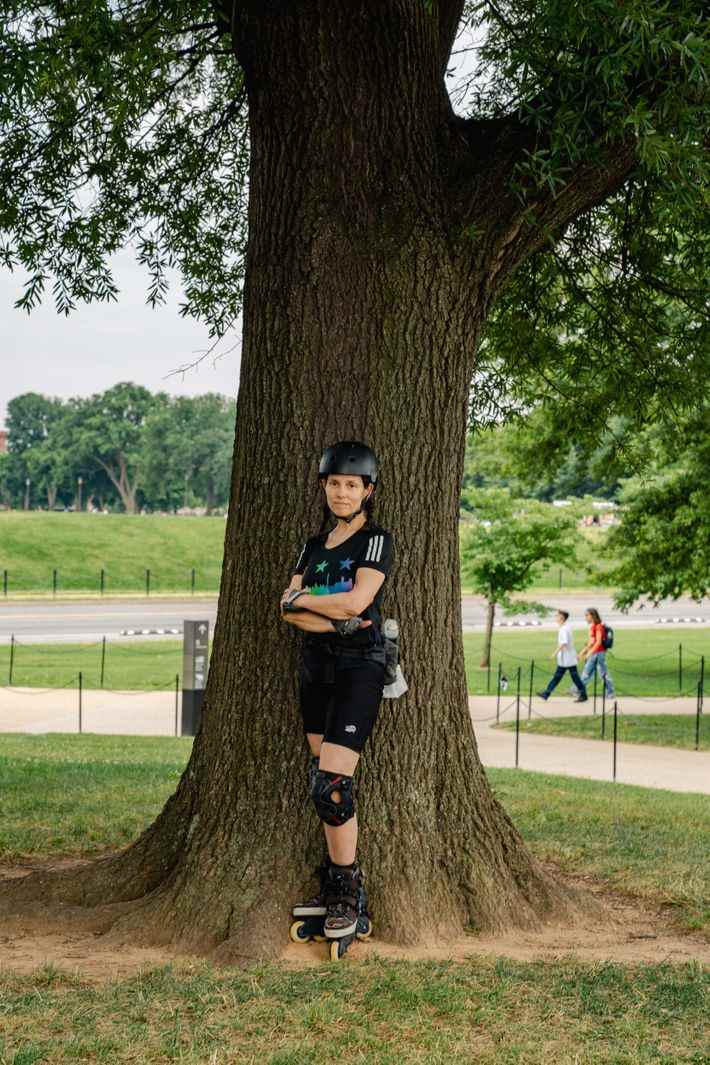 Une femme portant un casque, des genouillères et des patins à roues alignées représente un portrait lors du deuxième rassemblement March for Our Lives.